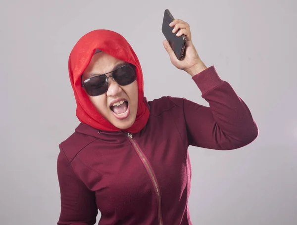 赤いスーツと彼女の携帯電話 スマート フォンの悪いニュースを持っていることのための怒っている動揺失望式を叫んで怒って投げるヒジャーブに黒のサングラスを身に着けているイスラム教徒の女性の肖像画 — ストック写真