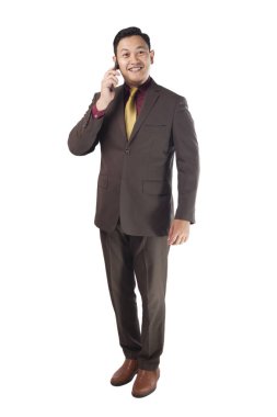 Telefonunu, jest, tam vücut portre üzerinde beyaz izole gülümseyen mutlu konuşurken çekici genç Asya iş adamı portresi