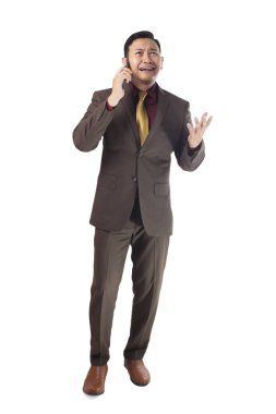 Genç Asyalı businesman kahverengi resmi elbise giymiş bir şey telefonla açıklamaya çalıştım kızgın, gibiydiler. Beyaz izole. Tam vücut portre