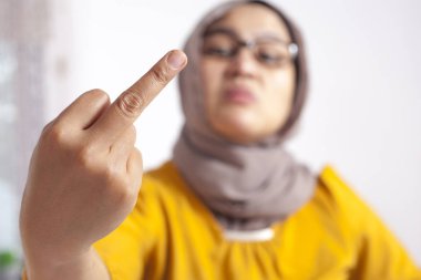 Kızgın kızgın Asya Müslüman kadın portresi orta parmak hareketi, ofiste kaba işkadını gösterir
