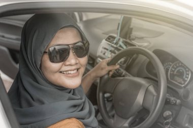 Sürücü sırasında arabasını eğleniyor yaşam tarzı gülümseyen Asya Müslüman kadın portresi tatil tatil gezi, araba sürmek kavramı paylaşımı