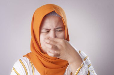 Sevimli komik Asya Müslüman Bayan hijab giyen portresi kötü iğrenç koku koku yüzünden burnunu kapat