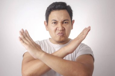 Genç funy kızgın Asya adam portresi çapraz kol hareketi gösterir, veren uyarmak jest, ret kavramı durdurmak için