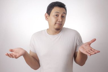 Photo image of funny Asian man with shrug shoulder up gesture, showing i don't know or rejection clipart