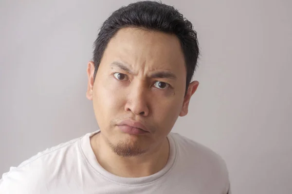 Photo image of funny Asian man showing cynical unhappy angry facial expression
