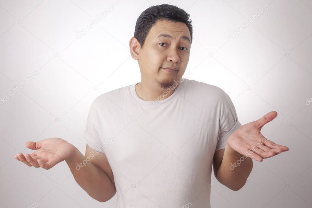 Photo image of funny Asian man with shrug shoulder up gesture, showing i don't know or rejection