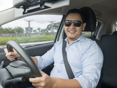 Gülümseyen ve sürme bir araba, iyi görünümlü girişimci, araba kavramı paylaşımı genç Asyalı adam portresi