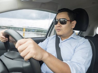 Gülümseyen ve sürme bir araba, iyi görünümlü girişimci, araba kavramı paylaşımı genç Asyalı adam portresi