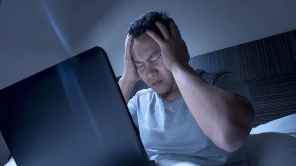 Cansado sonolento homem trabalhando no laptop até meia-noite na cama — Fotografia de Stock