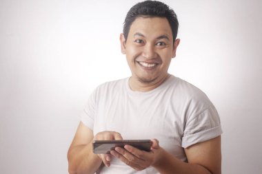 Komik genç Asyalı adam Tablet akıllı telefonda oyunlar oynamak