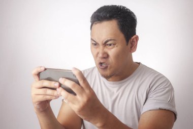 Komik genç Asyalı adam tablete oyunlar oynarken