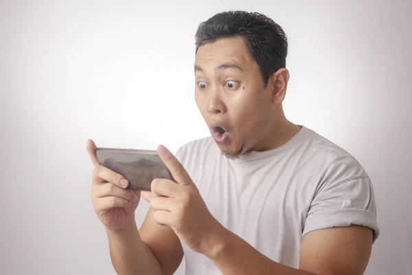 Funny Young Asian Guy Playing Games on Tablet Smart Phone — Stock Photo, Image