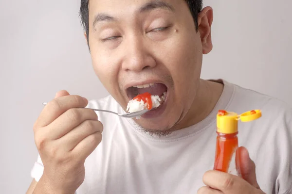 Азиатский человек ест рис с соусом самбал чили — стоковое фото