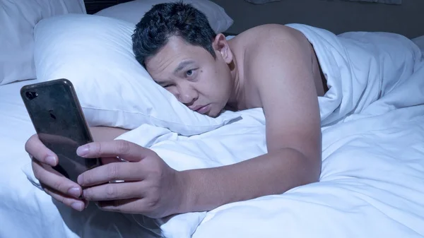 Telefone viciado, homem usando telefone inteligente na cama à meia-noite — Fotografia de Stock