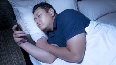 Telefon bağımlısı, adam gece yarısı yatak akıllı telefon kullanma