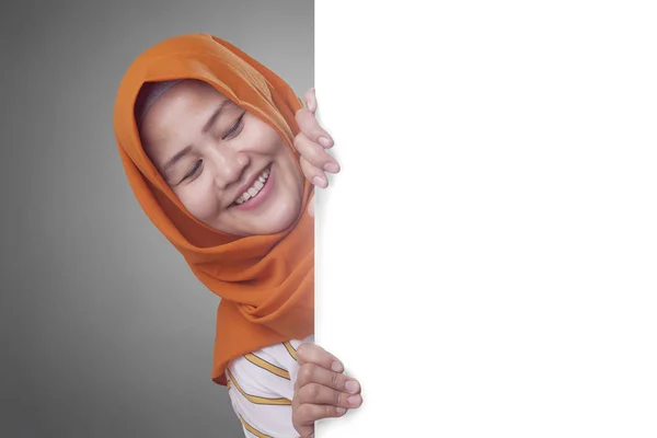 Νεαρή μουσουλμάνα γυναίκα χαμογελώντας πίσω από το λευκό πίνακα — Φωτογραφία Αρχείου