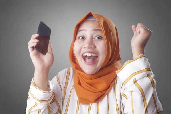 Ung muslimsk kvinde får gode nyheder på hendes telefon - Stock-foto