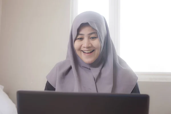 Felice donna musulmana che lavora con il computer portatile nella sua camera da letto — Foto Stock