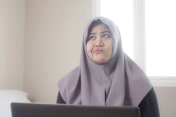 Muslim affärskvinna som arbetar på laptop hemma, tänkande gest — Stockfoto