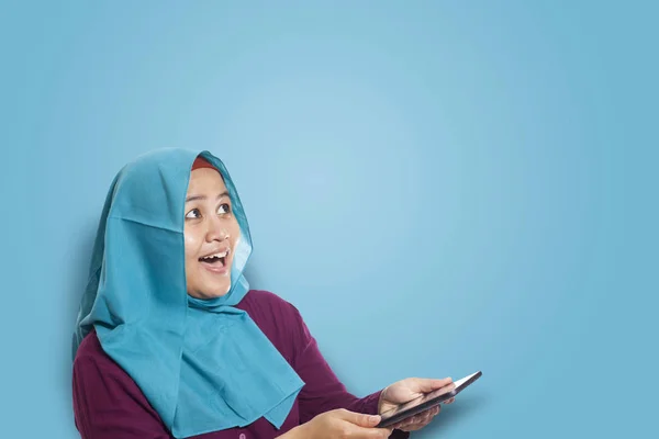 Mulher muçulmana surpreendida ao ver algo acima ao usar o telefone — Fotografia de Stock