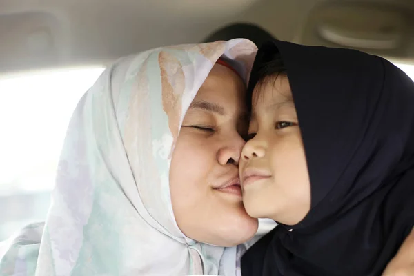 Feliz musulmán mamá y hija asiática madre beso su bebé niña —  Fotos de Stock