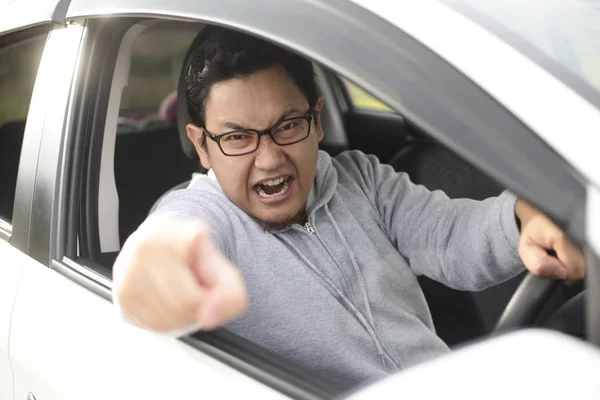 Enojado asiático conductor masculino, gritando señalando desde su coche —  Fotos de Stock