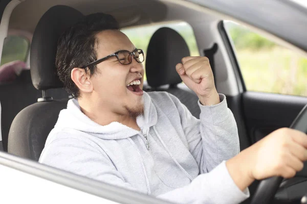 Asiático macho conductor conducir su coche y sonriendo —  Fotos de Stock