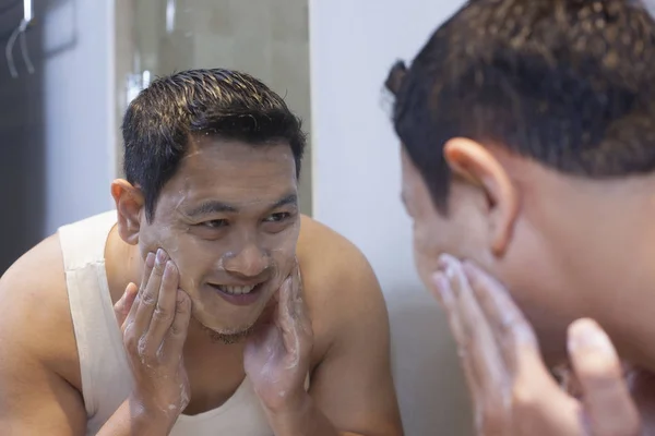 Man Wash his Face in Bathroom
