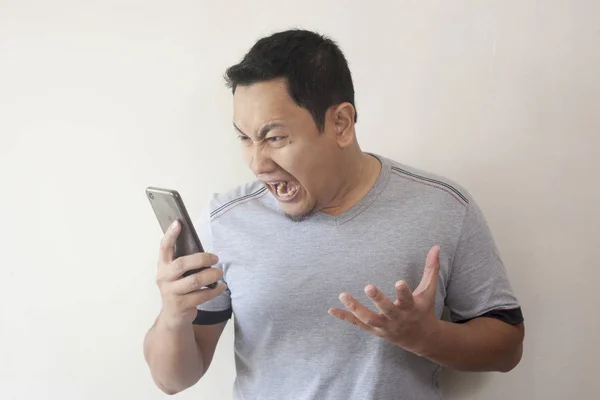 Jovem ficando más notícias no telefone, chocado e irritado — Fotografia de Stock