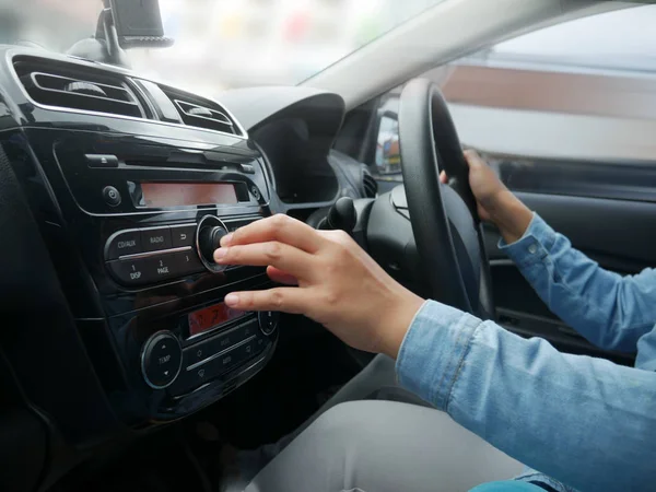 Autofahrerin drückt Taste am Autoradio — Stockfoto