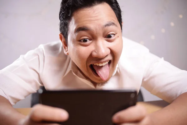 Funny Young Asian Guy Playing Games on Tablet Smart Phone — Stock Photo, Image