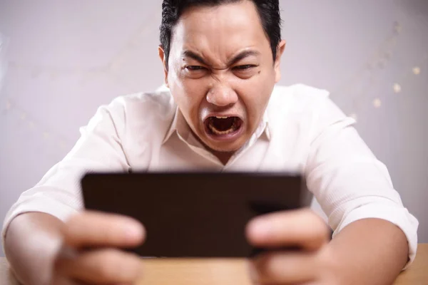 Lustige junge asiatische Kerl spielen Spiele auf Tablet — Stockfoto
