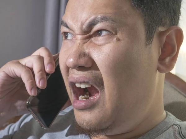 Junger Mann bekommt schlechte Nachrichten am Telefon, schockiert und wütend — Stockfoto