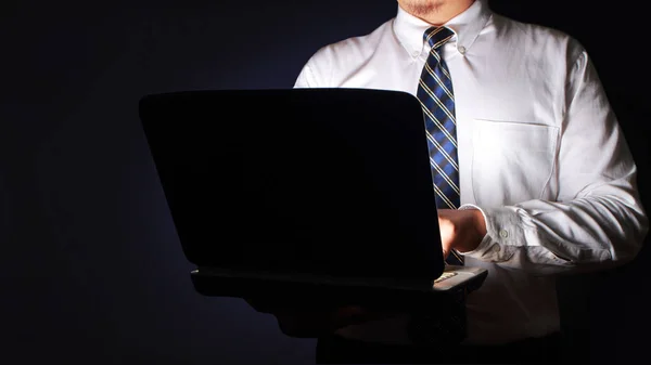 Empresário digitando no laptop no escuro — Fotografia de Stock