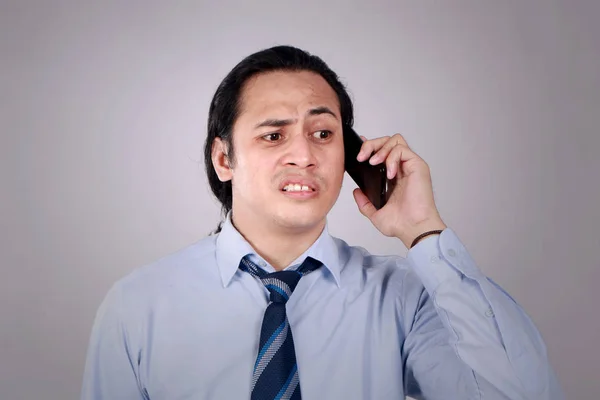 Mladý muž mluvící na telefonu, šokovaný ustaraný výraz — Stock fotografie