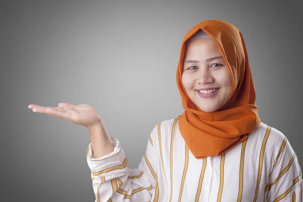 Muslim Lady mempersembahkan sesuatu di sisinya dengan Copy Space — Stok Foto