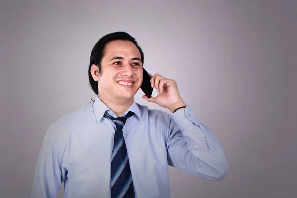 Genç adam konuşmayı telefonunu mutlu gülümseyerek gülüyor — Stok fotoğraf