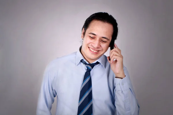 Genç adam konuşmayı telefonunu mutlu gülümseyerek gülüyor — Stok fotoğraf