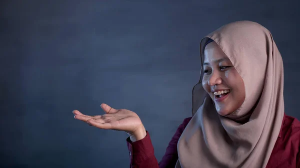 Lady muçulmana apresentando algo em seu lado com espaço de cópia — Fotografia de Stock