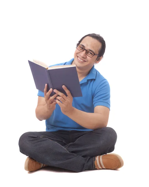 바닥에 앉아서 책을 읽고 있는 젊은이 — 스톡 사진