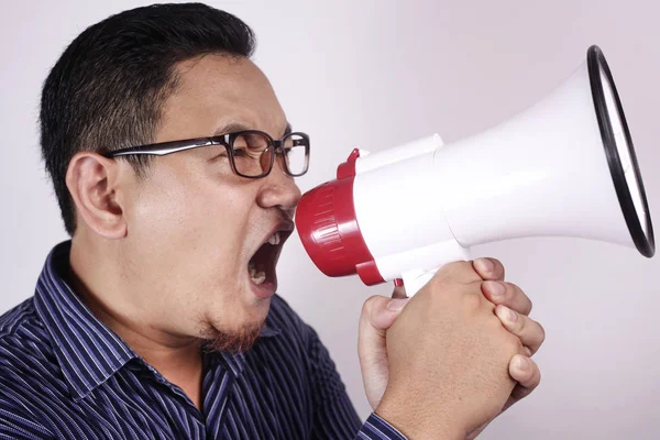 Joven gritando con megáfono, expresión enojada — Foto de Stock