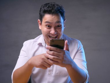 Mutlu gülümseyerek telefonundan sohbet mesaj okuma genç adam