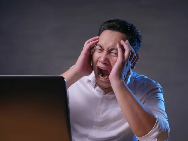 Νέος άνθρωπος κοιτάζοντας laptop, θυμωμένη χειρονομία — Φωτογραφία Αρχείου