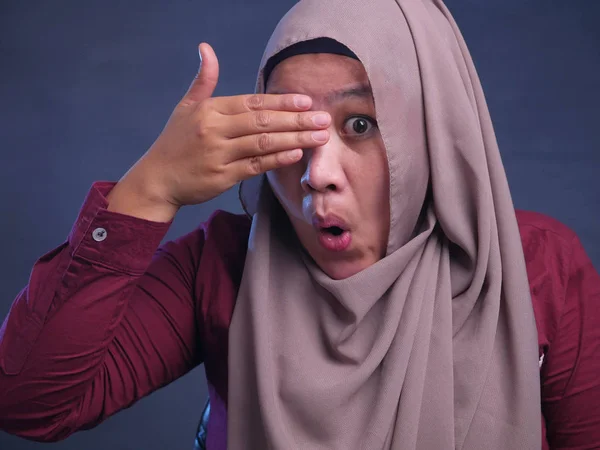 Мусульманская женщина подглядывает сквозь пальцы — стоковое фото