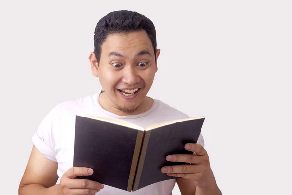 Hombre feliz sonriendo mientras lee el libro — Foto de Stock