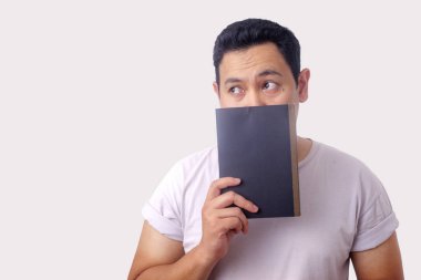 Genç adam Holding kitap, düşünme Ifadesi