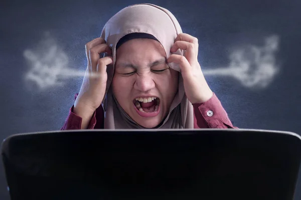 Mulher de negócios muçulmana irritada trabalhando no laptop no escritório — Fotografia de Stock