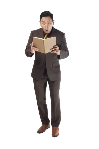 Asijský muž šokovaný při čtení knihy — Stock fotografie