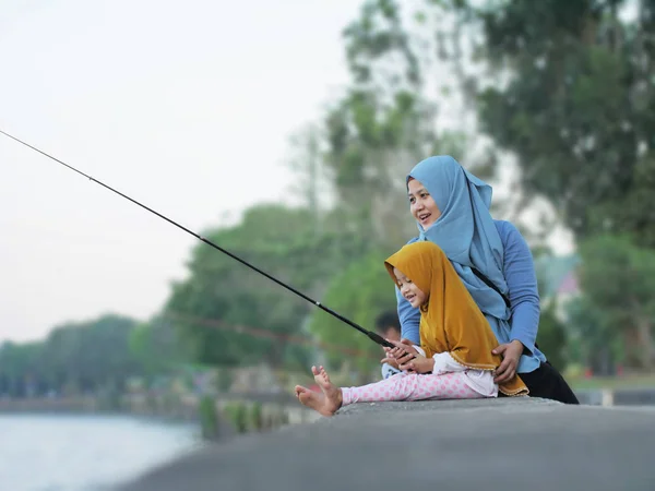 Mãe muçulmana e bebê pequeno pesca Daugter — Fotografia de Stock