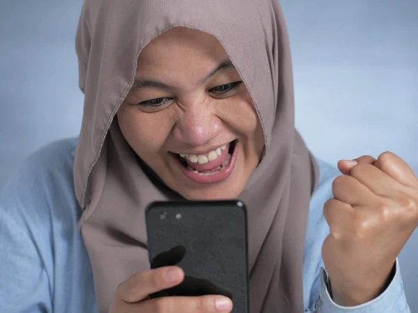 Jeune femme musulmane obtenir de bonnes nouvelles sur son téléphone — Photo